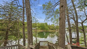 A wooden deck leading to a lake surrounded by trees. - Lakefront Retreat • Private Dock + Firepit + Game Room | Montclair Manor (Mooresville)
