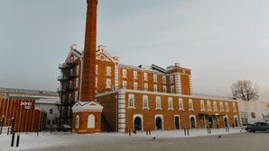 A large brick building with a tall chimney, multiple windows, and a central entrance. - Pana Unique Semey (Semipalatinsk)