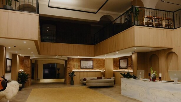 A spacious lobby with a high ceiling, a reception desk, a seating area, and a staircase leading to an upper level. - Pana Unique Semey (Semipalatinsk)