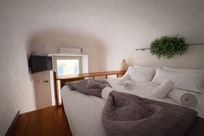 A bedroom with a bed, a TV mounted on the wall, a window, and a plant. - Esedra Loft, Like on a Boat Drifting Through Rome (Rome)