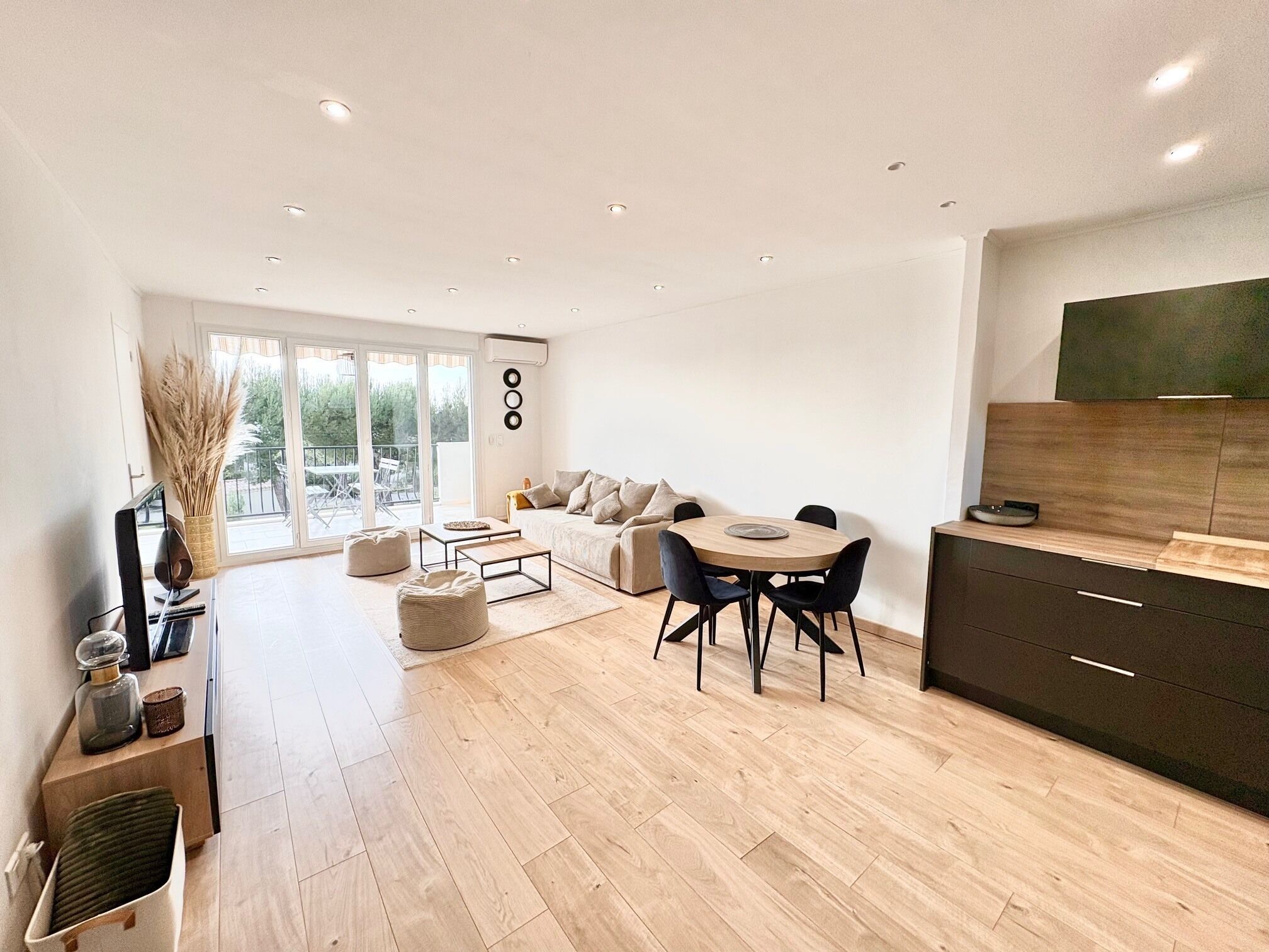 Un espacio habitable moderno con comedor, sofá y cocina.