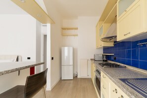 A compact kitchen with a refrigerator, stove, microwave, and a small dining area with a chair. - Comfortable 40m2 studio flat, ideal for 3 people, located on the third floor of a building with lift.The accommodation is located a stone's throw from Famagusta, characterized by a strong residential and student vocation, offering a quiet environment, gr (Milan)