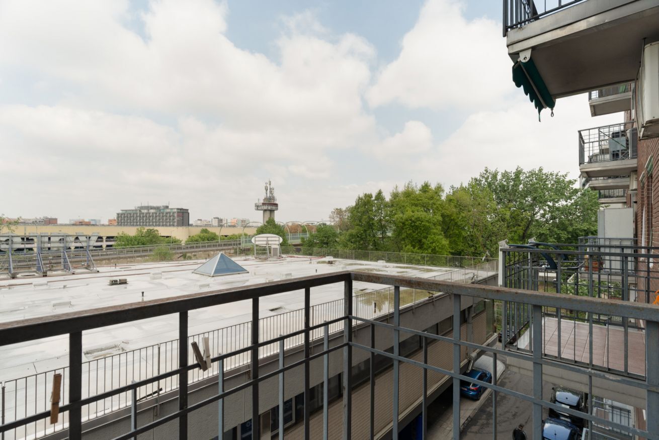 Vista dal tetto con una torre d'acqua, un'area parcheggio e un edificio con un balcone.