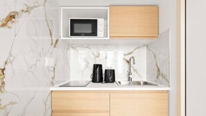 Une cuisine équipée d’un four à micro-ondes, d’une machine à café et d’un évier.