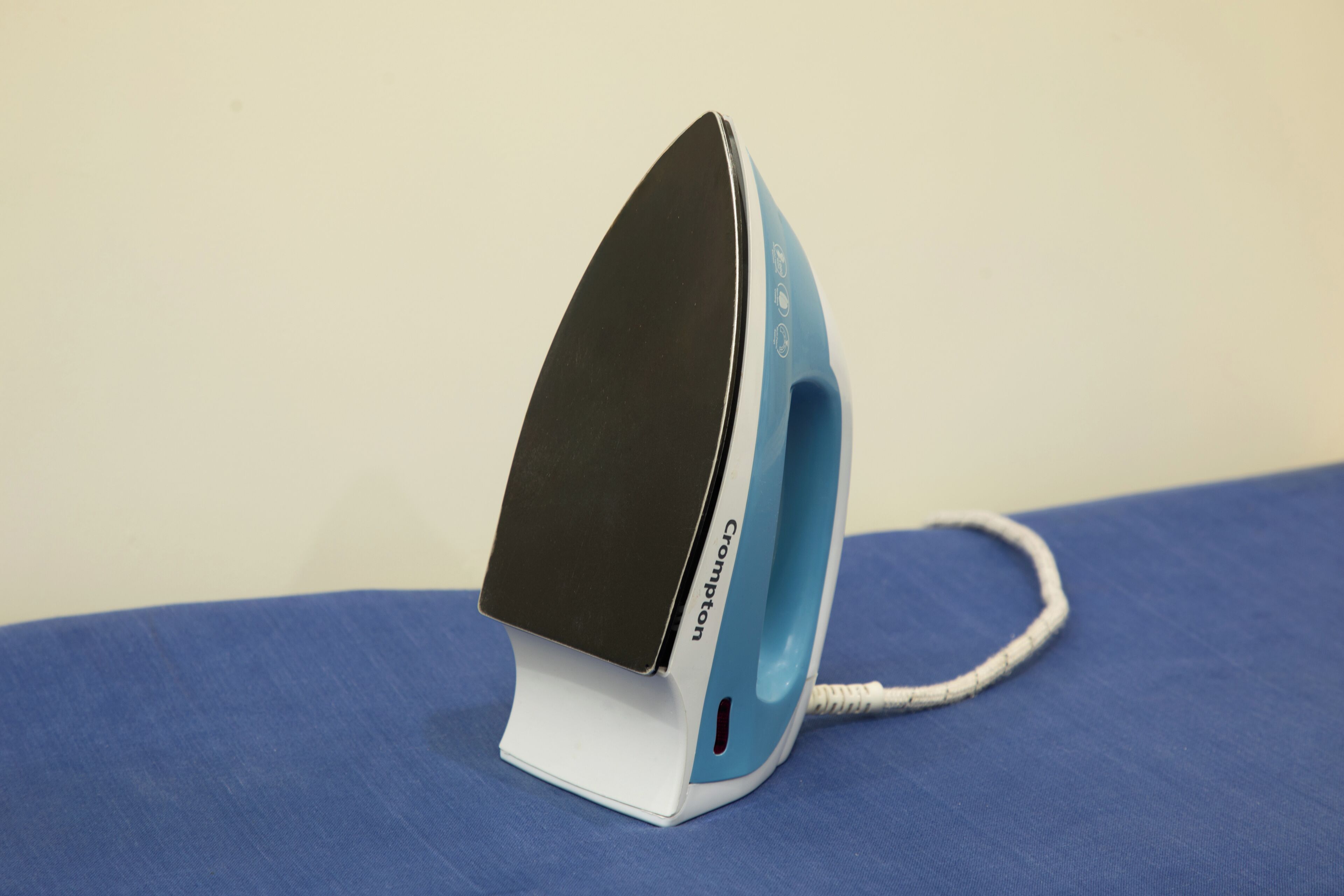 An iron on a blue surface.