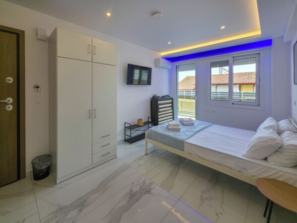 A modern bedroom with a bed, wardrobe, and a window with a view.
