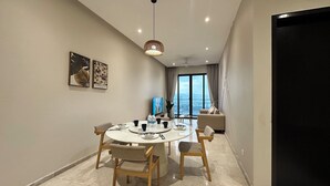 Un espace repas moderne avec une table ronde, des chaises et un luminaire au plafond.
