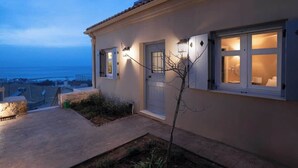 A house with a view of the sea, a white door, and two lit windows. - Ostria Studio, Kyparissia OldTown Home Collection (Kiparissia)