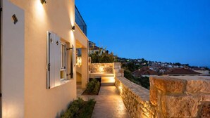 A modern building with a stone pathway leading to a stone wall and a balcony. - Ostria Studio, Kyparissia OldTown Home Collection (Kiparissia)