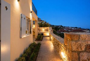 A modern building with a stone pathway leading to a stone wall and a balcony. - Ostria Studio, Kyparissia OldTown Home Collection (Kiparissia)