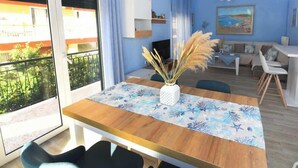 Una sala de estar moderna con una mesa de comedor de madera, un sofá y un televisor.