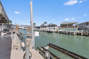 A waterfront property with dock access, a wooden deck, and a view of the water.