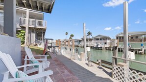 A waterfront property with a dock, outdoor seating, and a view of the marina. -  Welcome to Cocktails & Dreams! A Serene Waterfront Retreat w/ Direct Bay Access (Port Isabel)