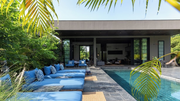 Un espace moderne aménagé au bord de la piscine, avec des sièges et une vue dégagée sur la piscine.