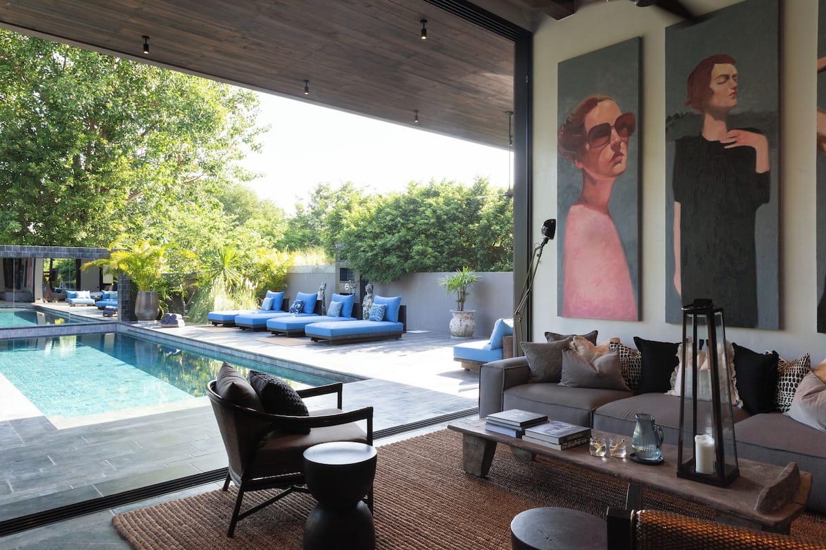Sala de estar moderna com piscina, área de estar externa e obras de arte.