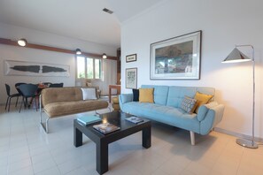 A living room with a sofa, coffee table, and a lamp. - Villa Montecristo - Diadema di Venere (Marina di Campo)
