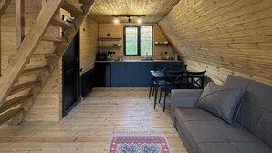 A wooden interior with a staircase, a sofa, a dining area, and a kitchen. - Your Peaceful Retreat in Kazbegi – Chalet with Stunning Views & Warm Charm (HHWF+JH, Sioni, Georgia)
