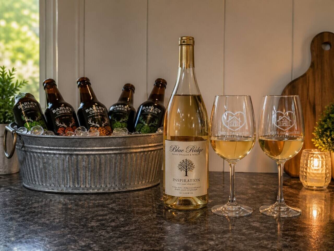 En flaske Blue Ridge vin, to glas og en spand med flere flasker Barley Creek vin.