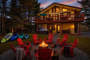 A two-story lodge with a deck, kayaks, and a fire pit. - Hot Tub & Fire Pit • 1 Min to Lake (lake harmony)