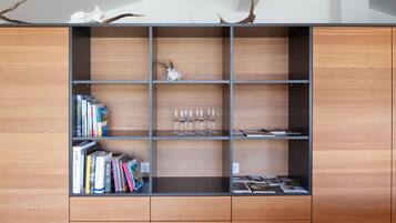 A wooden bookshelf with multiple shelves, some containing books and others with decorative items.