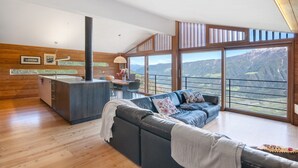 A modern interior with a sofa, dining area, and large windows offering mountain views. - Chalet Oberjuval – Unique and Stylish Retreat Amidst Alpine Meadows (Castelbello-Ciardes)