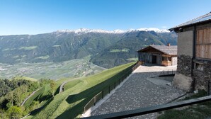 A mountain view with a stone building and a wooden structure. - Chalet Oberjuval – Unique and Stylish Retreat Amidst Alpine Meadows (Castelbello-Ciardes)