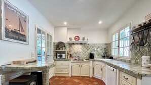 A kitchen with white cabinets, a tiled backsplash, a microwave, and a window with a view. - Dream villa with sea view and pool - family-friendly (Sainte-Maxime)