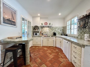 A kitchen with white cabinets, a tiled backsplash, a microwave, and a window with a view. - Dream villa with sea view and pool - family-friendly (Sainte-Maxime)