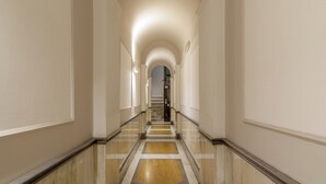 A long, narrow hallway with a marble floor and white walls. - Signature Rooms by Hannah Hotels Collection (Rome)
