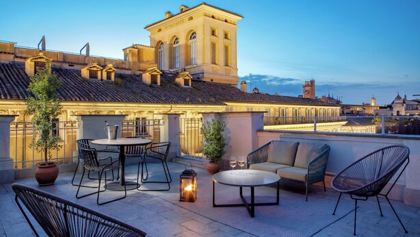 A rooftop terrace with outdoor seating, a potted plant, and a lantern. - Signature Rooms by Hannah Hotels Collection (Rome)