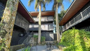 A multi-story building with balconies, outdoor seating, and a staircase. - Tagaytay Haven Ulat Managed by Novella (Tagaytay)