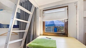 A room with a window, a wooden ladder, a green towel, and a white shelf. - Bauwagen 'Natur Pur/No.7' with Private Terrace and Panoramic Countryside Views (Ötisheim)