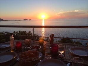 A table set for dinner with a sunset view over the water. - Marine de Palumbare (Monticello)