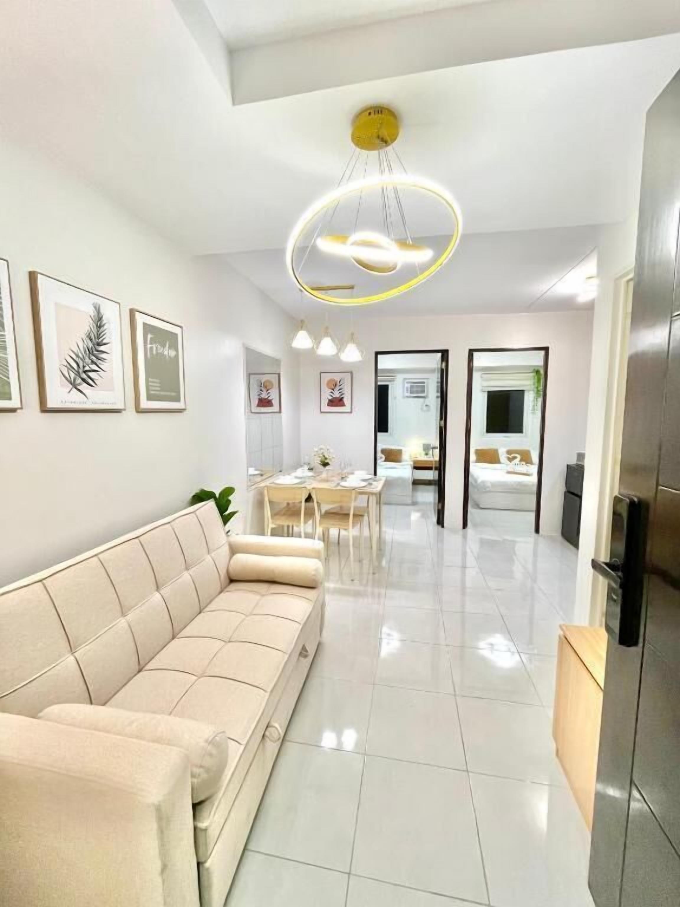 A modern living room with a sofa, dining area, and kitchen.