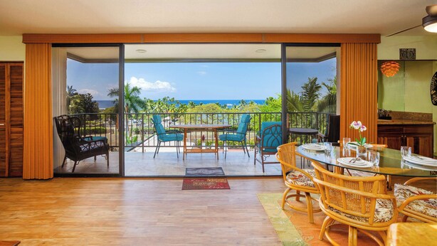 A room with a glass door leading to a balcony with a view of the ocean. - Sunset View at Kahaluu Bay Villas (Kailua-Kona)