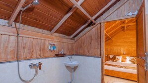 A wooden interior with a shower, sink, and a bed with a view. - Kampung Bingo Glamping & Resto (Baturiti)