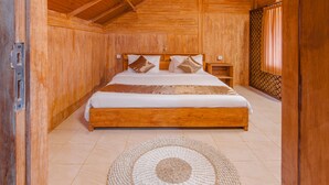 A wooden room with a large bed, a woven rug, and a window with curtains. - Kampung Bingo Glamping & Resto (Baturiti)