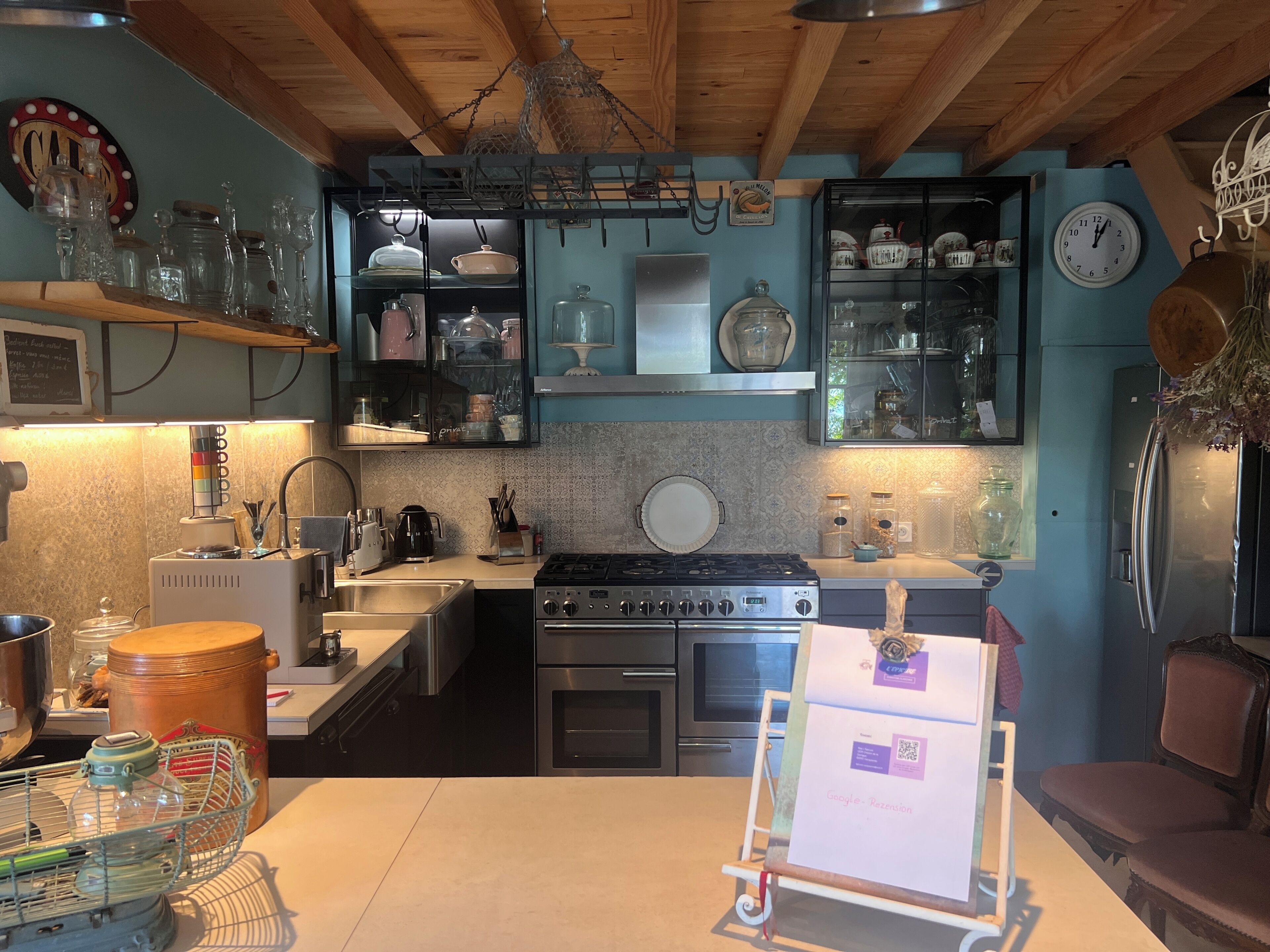 A kitchen with a stove, oven, sink, and various kitchenware.