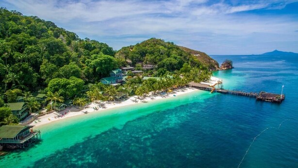 A coastal resort with a beach, clear turquoise waters, and lush greenery. - Rawa Island Resort (Mersing)