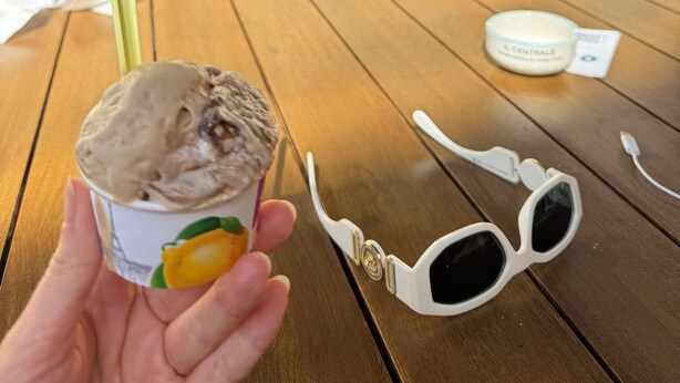 Une table avec une coupe de glace, une paire de lunettes de soleil et un pot de crème.
