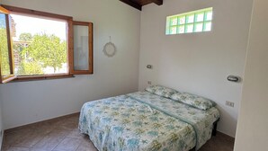 Une chambre à coucher avec un lit, une fenêtre, une porte et un plafond avec des poutres en bois.
