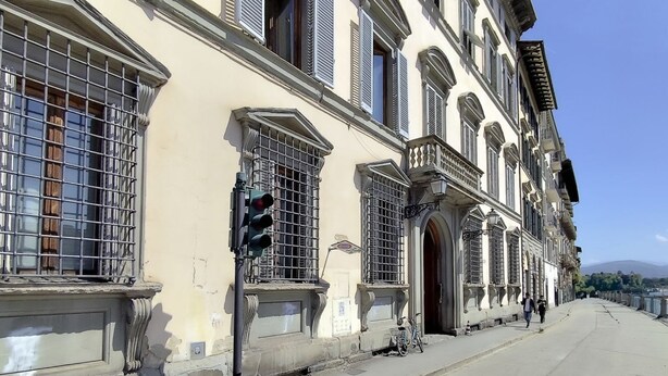 A historic building with large windows, a traffic light, and a bicycle parked outside. - Joyful Lungarno Apartment (Florence)