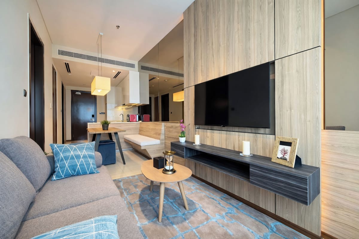 Ein modernes Wohnzimmer mit einer Couch, einem Couchtisch, einem Fernseher und einer Wand als Holzdekor.
