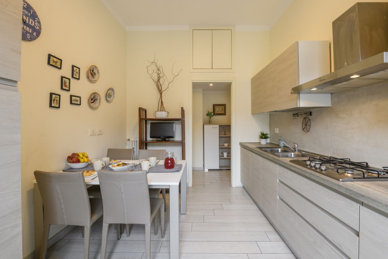 A modern kitchen with a dining area, a TV, and a built-in stove.
