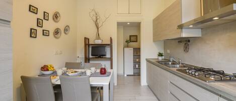 A modern kitchen with a dining area, a TV, and a built-in stove.