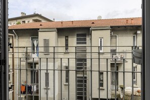 A multi-story residential building with balconies, a metal fence, and laundry hanging outside. - Tibaldi, 29 - Bright between Bocconi and Navigli (Milan)