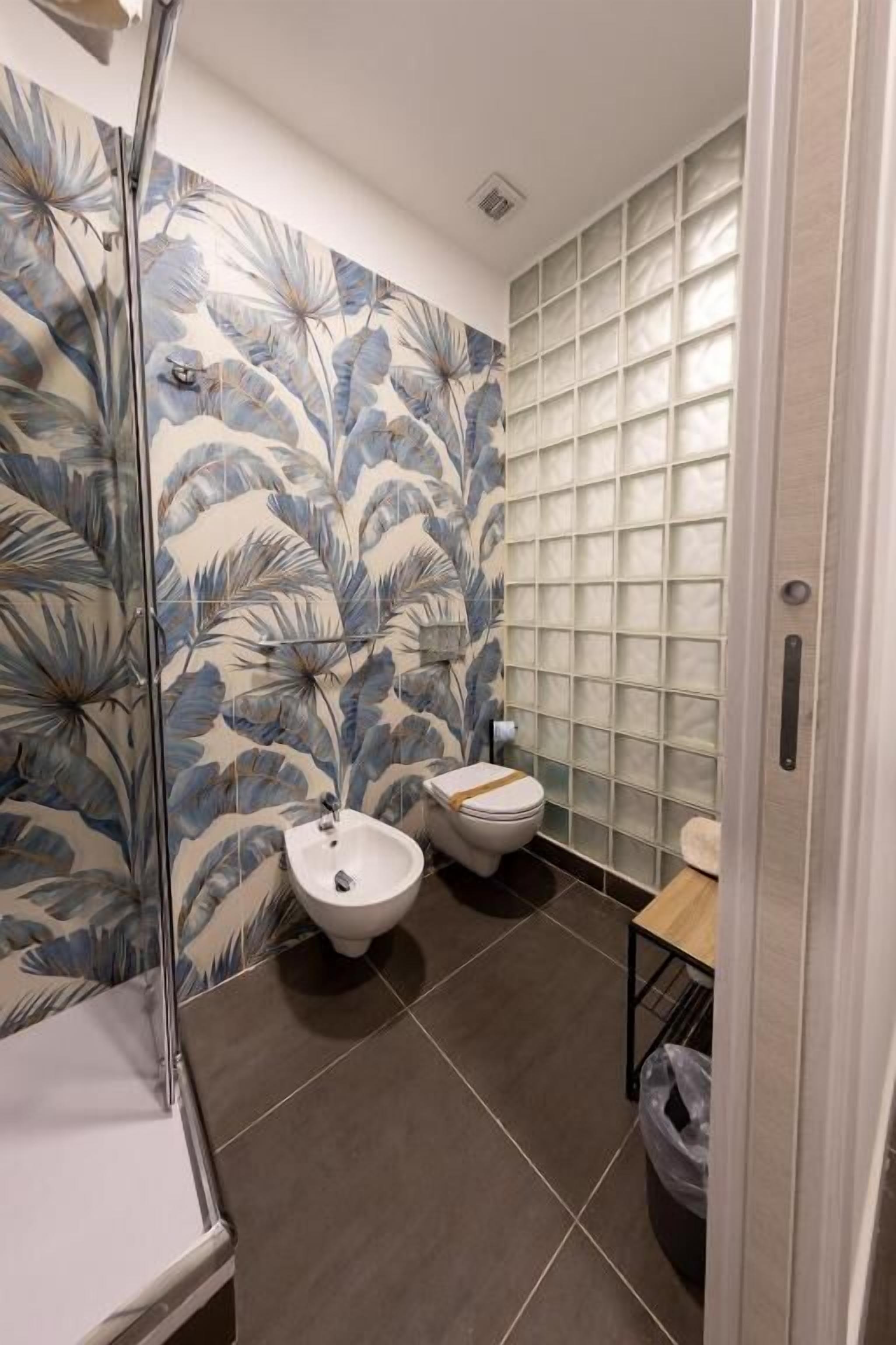 A bathroom with a shower, a bidet, and a toilet.