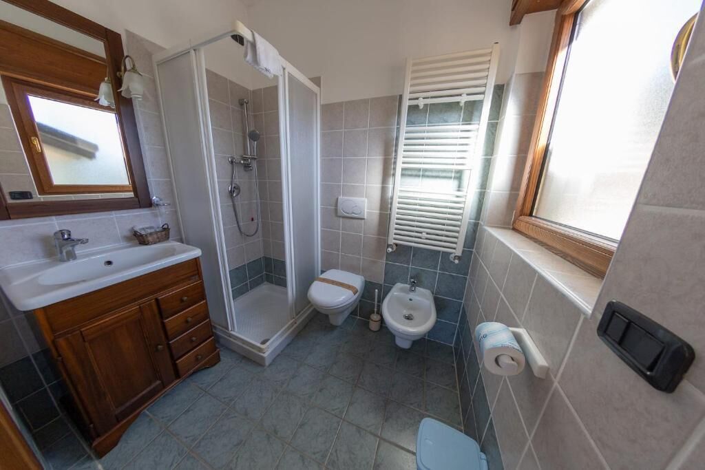 Ein Badezimmer mit Dusche, Toilette, Bidet und Waschbecken.