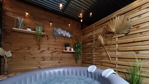 Un jacuzzi en una habitación de madera con estantes y plantas.