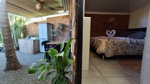 A room with a bed, a small table, and a potted plant. - Cabin 'La Cabane Tropicale' with Private Pool, Wi-Fi and Air Conditioning (Saint-Louis)